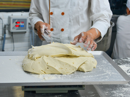 Preparing bread dough on table in a bakery. Food background.