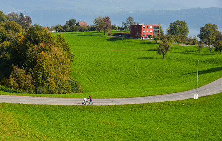 Lucerne, Switzerland - Oct 23, 2018. A young woman with baby trolley on rural road with beautiful landscape at summer in Lucerne, Switzerland.のeditorial素材