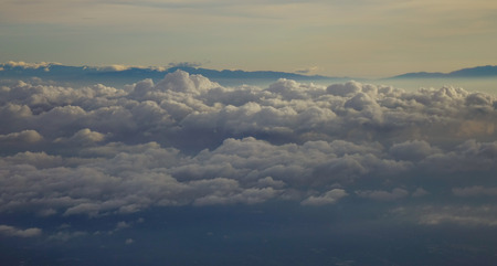 Blue sky with clouds, view from the flying airplane.