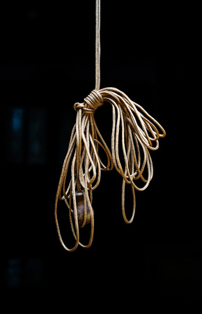 Hanging rope knot on black. Home related objects.の写真素材