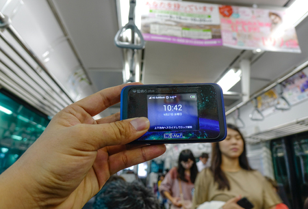 Akita, Japan - Sep 27, 2017. Holding mobile hotspot Wi-Fi device in the train. The device is very...