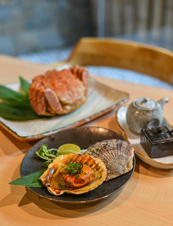 Grilled fresh scallop with soil sauce in hard shell.の写真素材