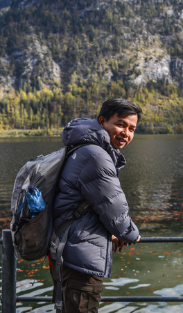 An Asian young man relaxing near the lake at Hallstatt, Austria.のeditorial素材