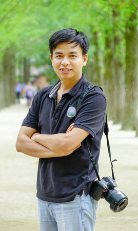 An Asian man standing at tree park on Nami Island, South Korea.のeditorial素材