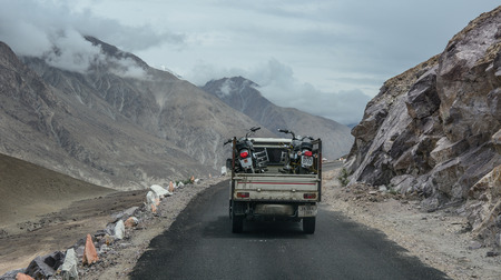 Ladakh, India - Jul 19, 2015. A truck carrying motorcycles on mountain road in Ladakh, India. Ladakh is renowned for its remote mountain beauty and culture.のeditorial素材