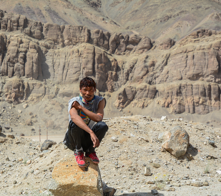 Ladakh, India - Jul 19, 2015. A Tibetan young man sitting on the rock in Ladakh, North of India.のeditorial素材