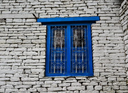 Blue wooden window with brick wall of rural house in Nepal.の写真素材