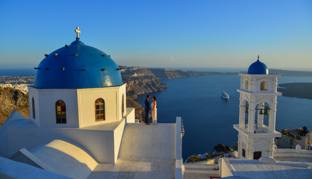 Santorini, Greece - Oct 4, 2018. A sweet couple standing at the Orthodox church on Santorini Island. Santorini is one of the most popular islands in the world.の写真素材