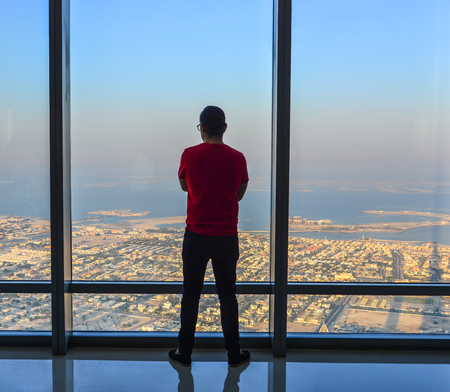 Dubai, UAE - Dec 7, 2018. A man enjoying at the observation deck of the highest building in the world, Burj al Khalifa.のeditorial素材