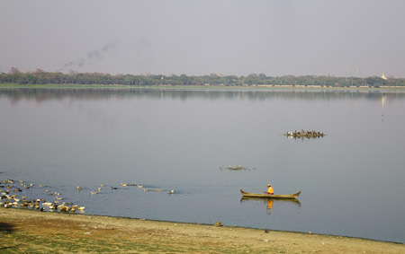 Mandalay, Myanmar - Feb 9, 2017. A man fishing on Lake Taungthaman (Burma). Tourists like to watch the tranquility and serenity of this beautiful lake.のeditorial素材