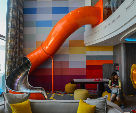 Shanghai, China - Jun 4, 2019. Interior living room with tube slider of Ultimate Family Suite on Spectrum of the Seas cruise liner by Royal Caribbean.のeditorial素材