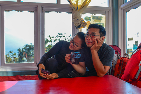 Khopra, Nepal - Oct 22, 2017. A young couple trekkers sitting at the teahouse on Annapurna Circuit Trek.のeditorial素材