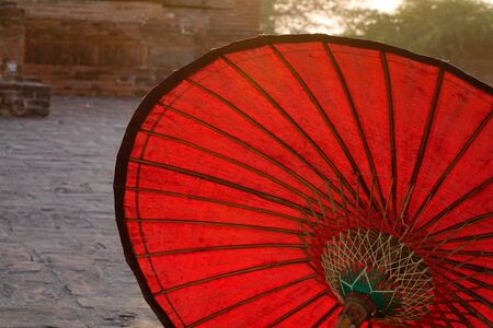 A red umbrella at Buddhist temple in Bagan, Myanmar.の写真素材