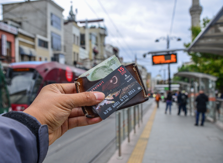 Istanbul, Turkey - Sep 27, 2018. Man hand holding a Istanbulkart at tram station. Istanbulkart is a smart card for fare payment on public transport in Istanbul.のeditorial素材