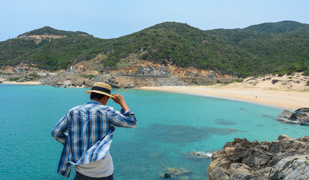A young man standing and looking at the blue sea in Nha Trang, Vietnam.のeditorial素材
