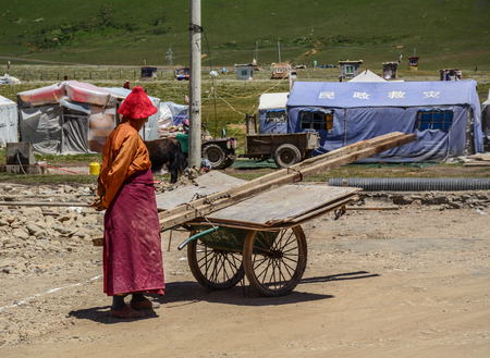 Sichuan, China - Aug 18, 2016. Tibetan monk on street near Yarchen Gar in Sichuan. Yarchen Gar is the largest concentration of nuns and monks in the world.のeditorial素材