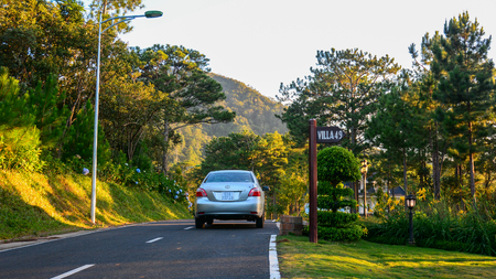 Dalat, Vietnam - Apr 5, 2015. A car on the country asphalt road through pine forests in early morning.のeditorial素材