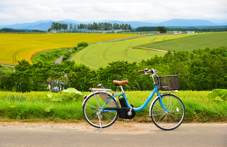 Furano, Japan - Jul 1, 2019. Bicycle on the road in front of the field farm in Furano, Hokkaido, Japan.のeditorial素材