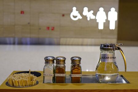 Counter in coffee shop with straws and sugar at shopping mall.