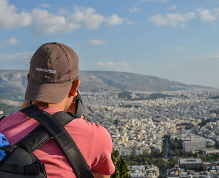 A man looking at the old city from a height of Athens, Greece.
