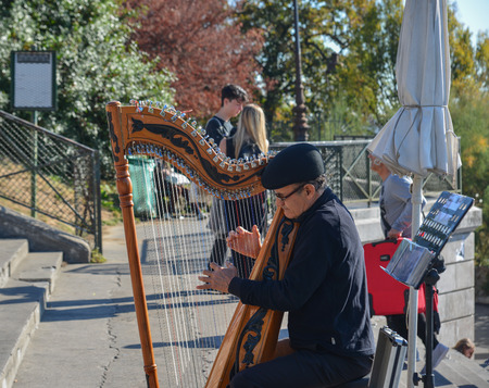 Paris, France - Oct 2, 2018. Musician playing harp at the streets of Paris, France. Paris was ranked as the third most visited travel destination in the world in 2017.のeditorial素材