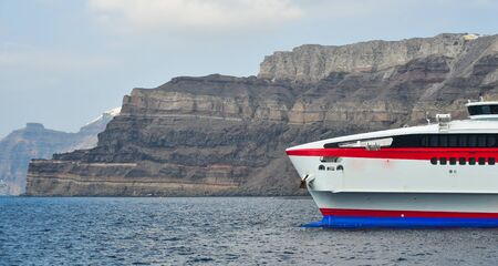 Beautiful sea with the ferry on Santorini island, Greece. Summer landscape, turquoise sea and blue sky.の写真素材