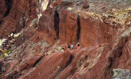 Santorini, Greece - Oct 10, 2018. Trekking on the red volcano mountain near red beach on Santorini Island, Greece.のeditorial素材