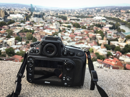 Tbilisi, Georgia - Sep 22, 2018. DSLR camera on the deck with Tbilisi cityscape background. Tbilisi is the capital and the largest city of Georgia.のeditorial素材