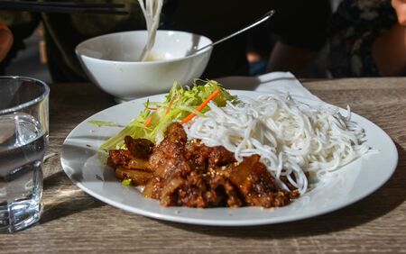 Fried beef with noodle (Bun Bo Xao) on table for lunch at the local restaurant. Vietnamese cuisine.の写真素材