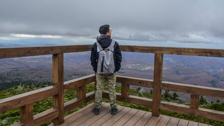 A man standing on the view point of Hakkoda Mountains. Hakkoda is one of the best fall destinations in the Tohoku region.の写真素材