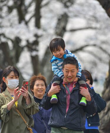 Tokyo, Japan - Apr 14, 2019. People enjoying cherry blossom (hanami) at the park. Hanami festivals drive billions into the economy as tourists flock to see the beautiful blossoms.のeditorial素材