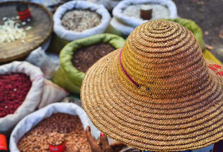 Woman wearing a traditional hat at rural market in Shan, Myanmar.の写真素材