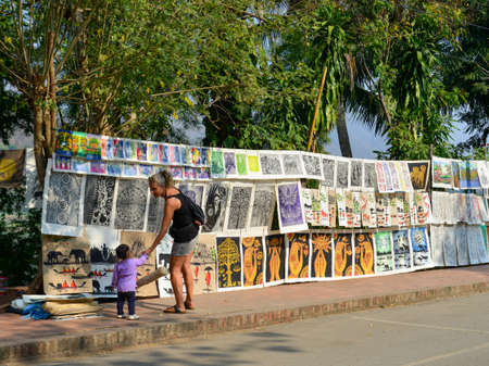 Luang Phrabang, Laos - Feb 4, 2020. Tourists are buying paintings on the street in Luang Phrabang, Laos. The city was the capital of the kingdom of Laos until 1975.のeditorial素材