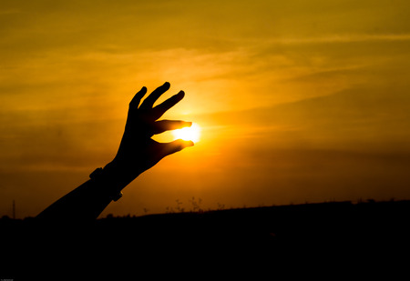 the hand grab the sun in sunset time, Phuket Thailandの写真素材