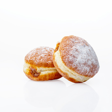 Two donuts with chocolate filling on a white background. Isolated items. Golden pastries dusted with powdered sugar. Studio.の写真素材