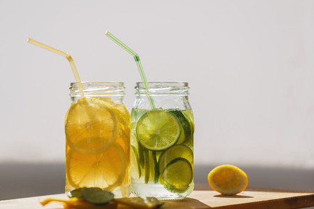 On the Board two cans of soda. Drinks - lemon and lime. Diffused light. Slices of citrus in a jar on...