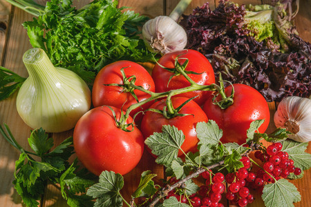 A variety of vegetables lying on a wooden Board. The ingredients for the salad on the table.の写真素材