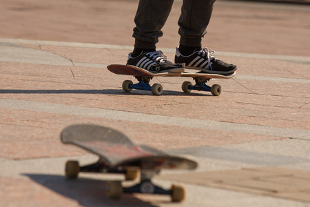 The teenager has prepared yourself how to skateboard. He is very diligent and persistent. The young man tore up shoes, learning skateboarding.の写真素材