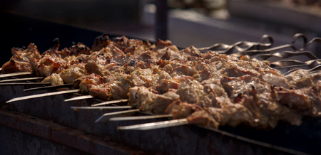 Skewers of meat on a hot grill closeup. Grilled meat on skewers. Outdoorsの写真素材