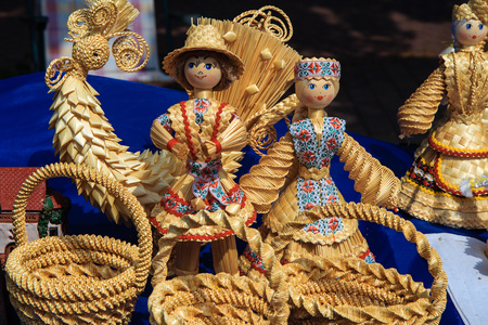 Showcase woven products from straw handmade at the village fair. Dolls, birds and baskets. Products of Belarusian masters.の写真素材