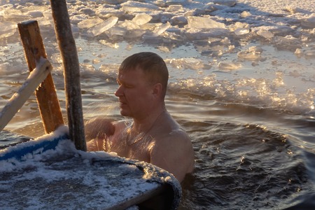 19.01.14 Polotsk Belarus. Swimming in the hole in the morning in the cold on the feast of the Baptism of the Lord. Men lead a healthy lifestyle and to do this in the winter swimming in the icy water.のeditorial素材