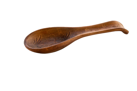 Object one large red ceramic spoon is presented on a white background. Large clay spoon with rest ornament isolated on white. Ceramic holder with spoon on white background. Side view.の写真素材