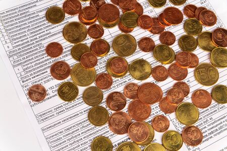 Coins of various denominations lying on the receipt for payment of utility bills in Belarus. The...