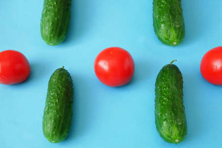 fresh organic cucumbers and tomato on blue backgroundの写真素材