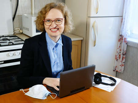 Business woman in a jacket and office shirt working remotely at home. Home office in quarantine time. Coronavirus and business conceptの写真素材