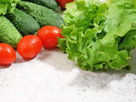 fresh zucchini, cucmber, tomato, lettuce and vegetables on gray background, healthy food concept