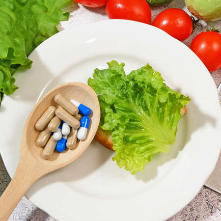 Healthy food vs pills. Salmon, vegetables and fruis vs medicine and drugs. Conceptの写真素材