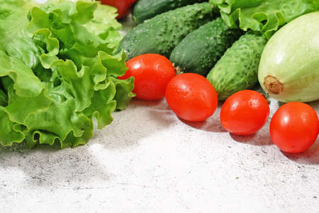 fresh zucchini, cucmber, tomato, lettuce and vegetables on gray background, healthy food conceptの写真素材