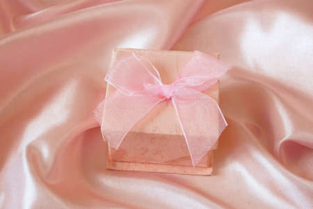 wedding rings in a gift box on pink silk background