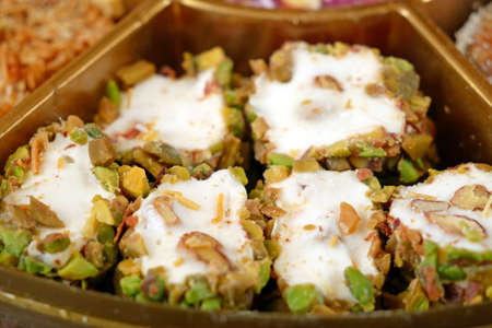 Eastern sweets with nuts, candy, dates in box background, closeup